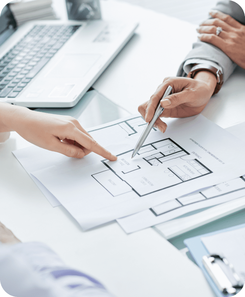 Hands discussing architectural floor plan documents.